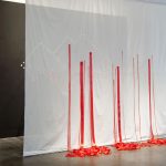 Bloodlines, an installation comprised of ribbon, wall, and scrim